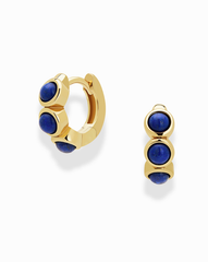The Corynn Gemstone Huggies by Mod + Jo are 18k gold plated earrings, each set with three vertical round deep blue natural lapis lazuli stones, shown on a plain white background.