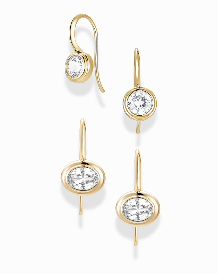 The Mod + Jo French Hook Earring Set features four gold French hook earrings—two with round and two with oval lab-grown white sapphires—arranged on a white background, each showcasing a simple, elegant design.