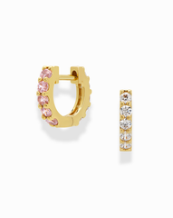 The Harlow Reversible Birthstone Huggies by Mod + Jo are small gold-plated hoops, with one side set with pink gemstones and the other with clear white stones, shown on a white background.
