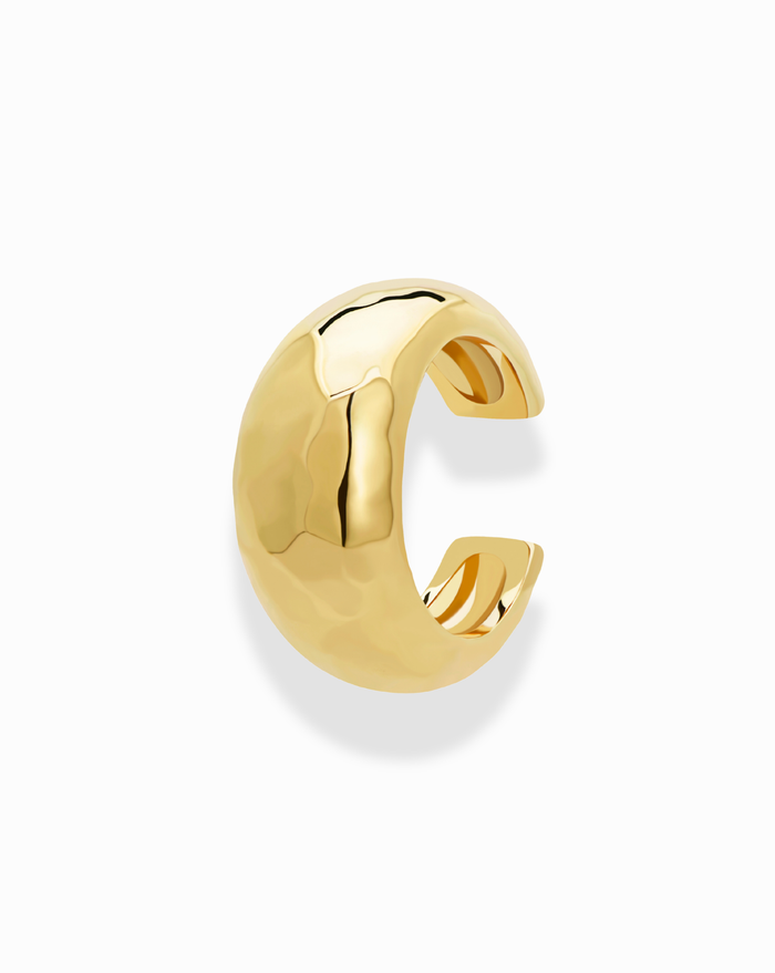 The Logan Hammered Ear Cuff by Mod + Jo is pictured on a plain white background, showcasing its domed, rounded gold shape, hammered texture, and polished, tarnish-free finish that reflects light.