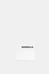 Comme des Garçons Parfums Marseille EDT packaging carré blanc épuré avec inscription noire centrée fond neutre