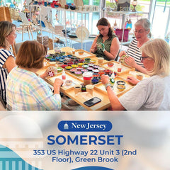 Group of women creating colorful mosaic art at a workshop in a bright studio