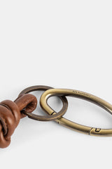 Bea Mombaers détail anneau rond laiton vieilli relié mousqueton ovale cuir cognac noué SS25