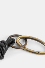 Bea Mombaers détail fermoir carabiner ovale doré vieilli gravé sur porte-clés cuir noué noir