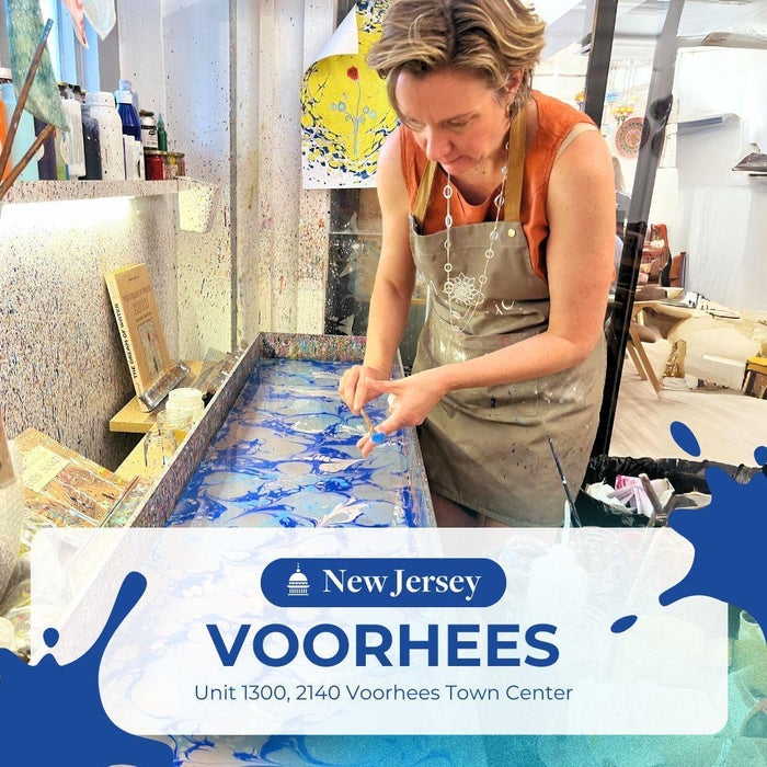 Woman creating blue ebru art using water marbling technique in art studio at Voorhees, New Jersey