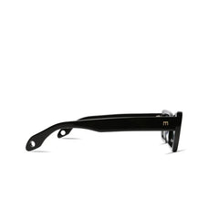 Side view of black Cookie Sunglasses by Elisa Johnson, crafted from acetate with thick arms, a small gold "m" logo near the hinge, and rounded holes at each arm’s end. These cat-eye frames provide stylish UV400 protection against a white background.