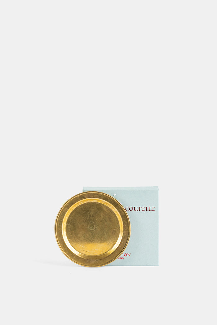 Trudon coupelle laiton doré posée contre son coffret bleu pâle collection FW26 accessoire bougie luxe