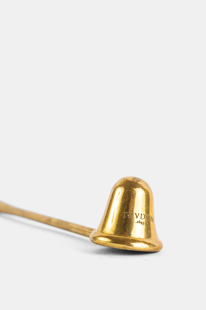 Trudon éteignoir laiton gravé logo 1643 cloche dorée posée sur fond blanc vue rapprochée