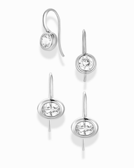 The Mod + Jo French Hook Earring Set features rhodium-plated earrings with bezel-set lab-grown white sapphires, displayed on a white background to highlight their simple, elegant design from various angles.
