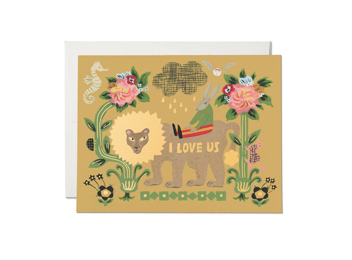 The Lion and Rabbit love greeting card by Red Cap Cards features a yellow background with a deer in a red sweater holding an umbrella over a lion, surrounded by flowers. Printed on heavyweight cardstock with "I LOVE US" beside the lion. Envelope included.