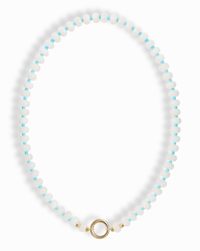The Macey Gemstone Necklace by Mod + Jo features alternating white jade and light blue round beads, finished with a gold circular clasp at the bottom center.