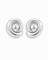 The Mod + Jo Milley Spiral Statement Studs are shiny silver earrings with a modern, rounded spiral design—perfect hypoallergenic accessories for contemporary style lovers. Presented on a plain white background.