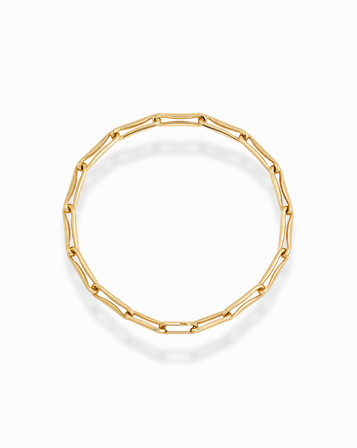 The Molly Elongated Link Chain Bracelet by Mod + Jo showcases elongated, oval-shaped gold links arranged in a circular design and displayed on a white background. This elegant bracelet elevates any layered look with its sophisticated style.