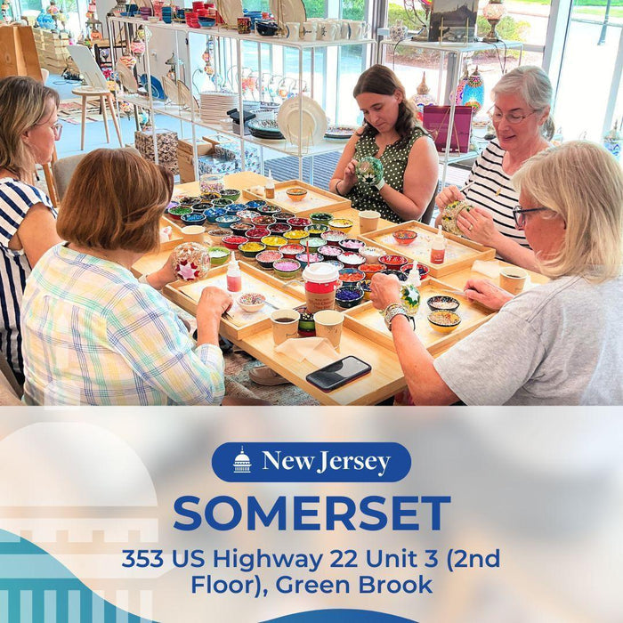 Group of women creating colorful mosaic art at a workshop in a bright studio