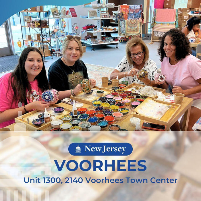 Four women crafting mosaic art projects with colorful beads at Voorhees Town Center in New Jersey