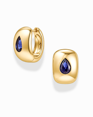 A pair of Mod + Jo Penn Gemstone Hoops in gold plated brass, designed in a rounded square huggie style and set with a teardrop-shaped blue gemstone at the center, accented by delicate CZ stones. Shown on a white background, these nickel-free earrings offer comfortable wear.