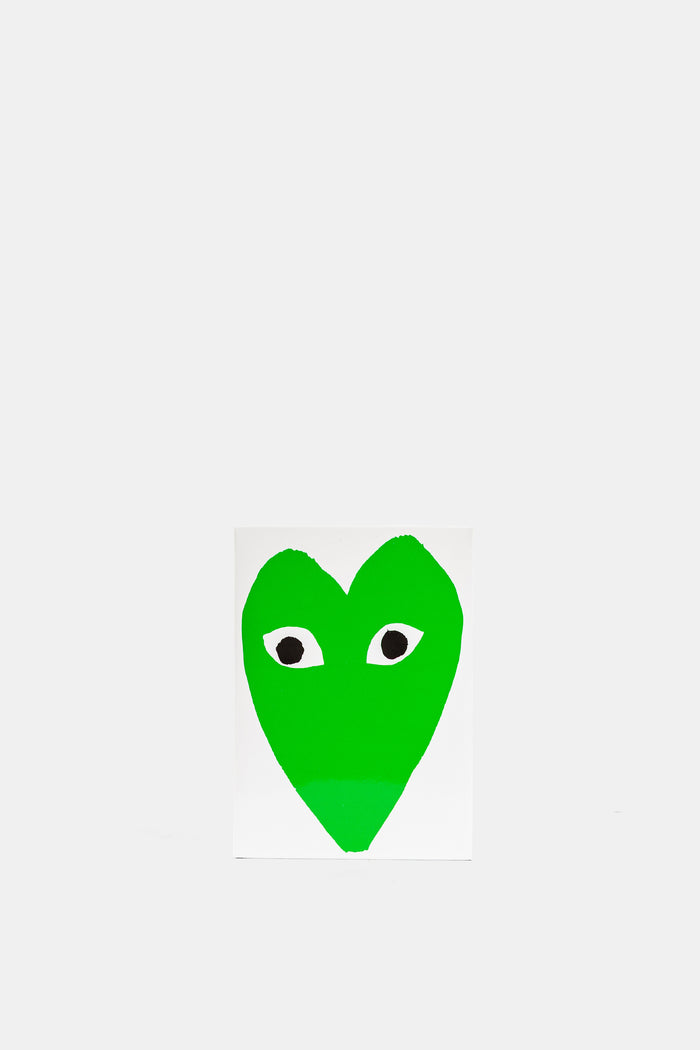 Comme des Garçons Parfums Play Green EDT illustration cœur vert vif avec yeux noirs sur carte blanche