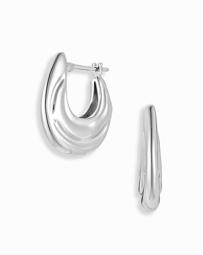 The Mod + Jo Samara Hoops are chunky, polished silver earrings with a wavy, modern design and advanced plating, shown from two angles on a white background.