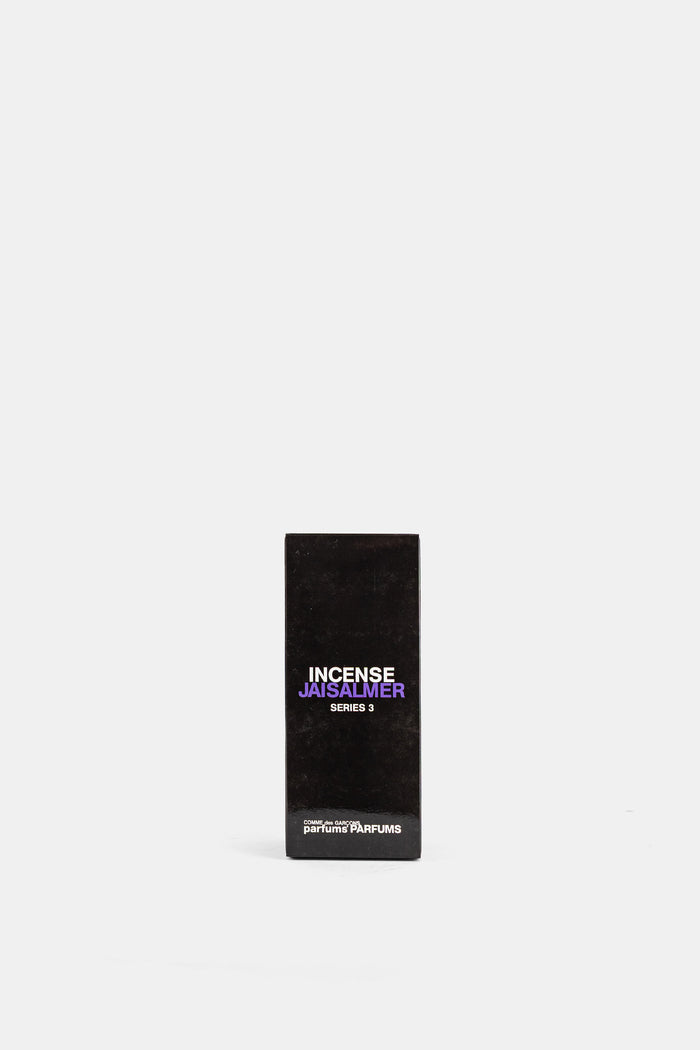 Comme des Garçons Parfums Jaisalmer Series 3 emballage noir mat typographie violette et blanche fond blanc