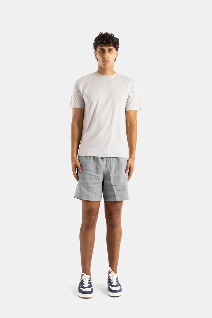 Handvaerk t-shirt homme coton Pima porté avec short gris et sneakers, look casual luxe saison printemps-été