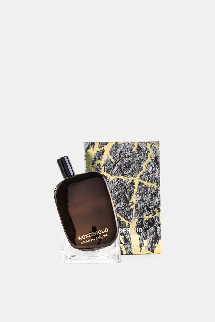 Comme des Garçons Parfums Wonderoud coffret écorce dorée avec flacon parfum posé devant son étui luxe